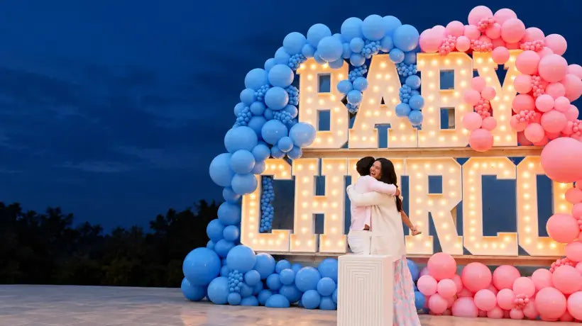 Gender reveal smoke celebration with pink and blue balloons