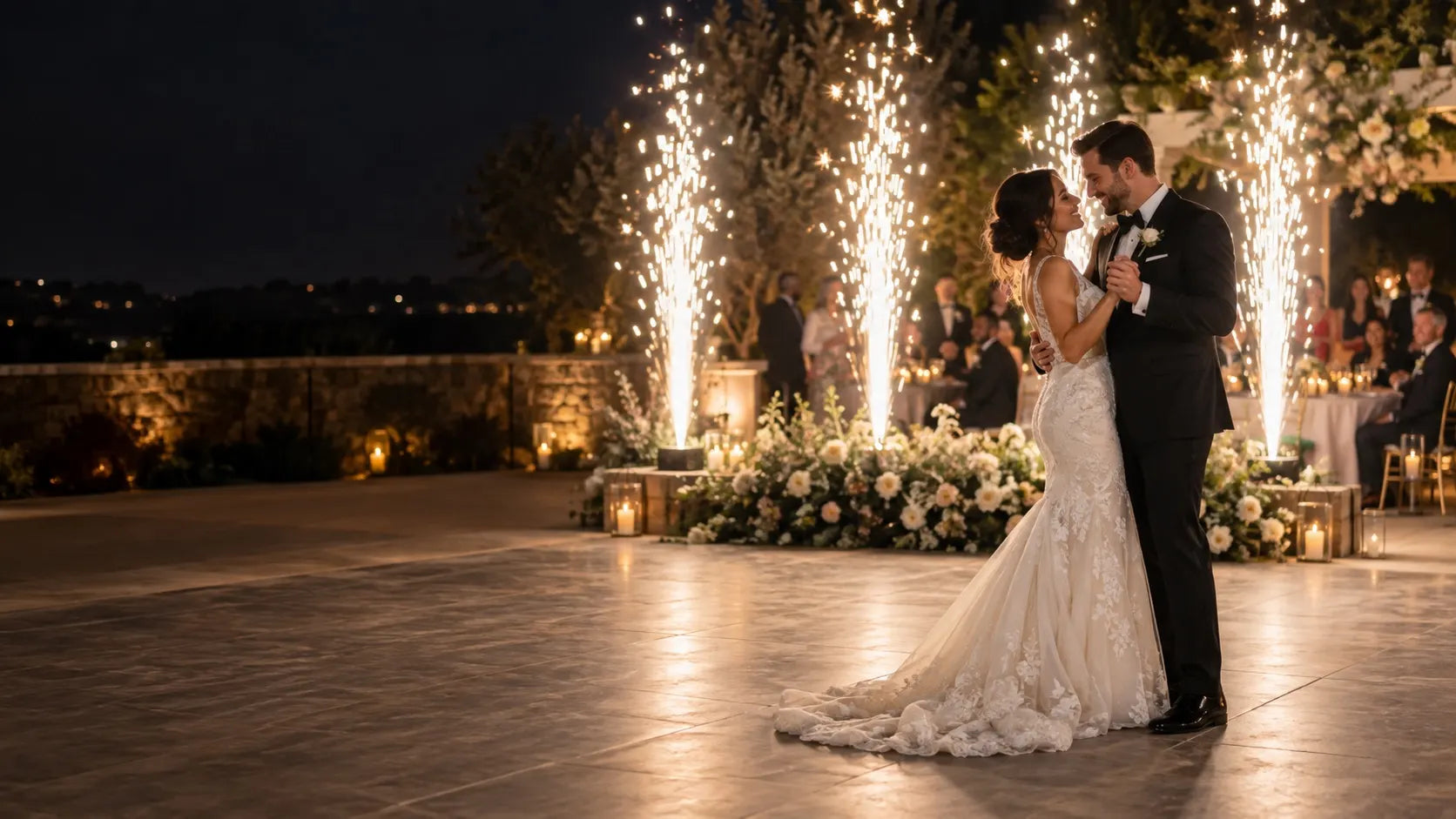 Newlywed couple dancing beside cold spark fountains